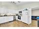 Bright kitchen with white cabinets, stainless steel appliances, and durable laminate flooring at 203 Birmingham Dr, Summerville, SC 29486