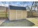 A backyard view showing a convenient tan wooden outbuilding with a blue metal roof for extra storage at 203 Birmingham Dr, Summerville, SC 29486