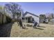 Spacious backyard features a fire pit surrounded by blue Adirondack chairs, wooden fence, and screened porch at 2058 Willowdale Ct, Mount Pleasant, SC 29466