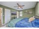 Bedroom with natural light features a ceiling fan, light green walls, hardwood floors, and a television on the wall at 206 Braly Dr, Summerville, SC 29485