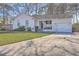 Charming white brick home featuring a well-manicured lawn, lush landscaping, and concrete driveway at 206 Braly Dr, Summerville, SC 29485