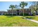 Traditional brick apartment building with palm trees, well-maintained lawn, and pedestrian walkway at 21 Rivers Point Row Row # 17 B, Charleston, SC 29412
