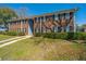 Two-story brick apartment building featuring dark shutters, lush bushes, and a well-maintained lawn at 21 Rivers Point Row Row # 17 B, Charleston, SC 29412