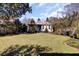 Expansive backyard featuring a manicured lawn, a patio dining set and landscaping at 214 E Doty Ave, Summerville, SC 29483