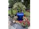 Backyard featuring a blue fountain, colorful flowers, and a variety of potted plants at 214 E Doty Ave, Summerville, SC 29483