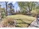 Expansive backyard with a well-maintained lawn, mature trees, and a shed at 214 E Doty Ave, Summerville, SC 29483