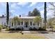 Charming white home with red roof, brick walkway and front porch at 214 E Doty Ave, Summerville, SC 29483