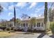 Charming white home with red roof, brick walkway and front porch at 214 E Doty Ave, Summerville, SC 29483