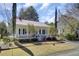 Charming white home with red roof, brick walkway and front porch at 214 E Doty Ave, Summerville, SC 29483