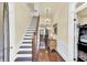 Bright foyer featuring a staircase, hardwood floors, elegant lighting, and a decorative console table at 214 E Doty Ave, Summerville, SC 29483