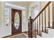 Grand foyer featuring an ornate front door with sidelights and staircase with dark wood banister and white risers at 214 E Doty Ave, Summerville, SC 29483