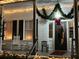 Charming front porch decorated with lights and holiday greenery around the door and hanging lantern at 214 E Doty Ave, Summerville, SC 29483
