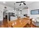 Open-concept kitchen with white cabinets, stainless steel appliances, a kitchen island, and a wooden dining table at 214 E Doty Ave, Summerville, SC 29483
