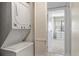 Stacked washer and dryer with white cabinets in hall leading to sunlit bedroom at 214 Sea Cloud Cir, Edisto Island, SC 29438