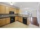 Traditional kitchen with wood cabinets, black appliances, and a view into the adjacent living room at 2244 Ashley Crossing Dr # 1236, Charleston, SC 29414