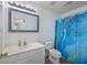 Cozy bathroom with single sink vanity and framed mirror, complemented by a toilet and blue patterned shower curtain at 234 Darcy Ave, Goose Creek, SC 29445