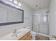 Bright bathroom featuring a framed mirror, a single sink vanity, toilet, and a shower with glass sliding doors at 234 Darcy Ave, Goose Creek, SC 29445