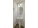 Cozy powder room featuring a pedestal sink, circular mirror, and modern lighting at 234 Darcy Ave, Goose Creek, SC 29445