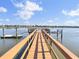 View down long dock from end with boat slips, dock, stairs, and pilings, with beautiful views of the water at 2399 Furman Dr, Charleston, SC 29414
