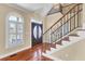 Inviting foyer with double doors, decorative window, and elegant staircase with iron railings, showcasing the home's refined features at 2399 Furman Dr, Charleston, SC 29414