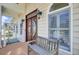 Elegant front entrance with a decorative wooden door and a cozy bench at 2399 Furman Dr, Charleston, SC 29414