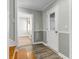 Hallway featuring a staircase, entry door and a glimpse into a sunlit room with hardwood floors at 2399 Furman Dr, Charleston, SC 29414