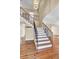 Elegant staircase features hardwood steps, decorative iron railings and a modern light fixture, adding to the home's charm at 2399 Furman Dr, Charleston, SC 29414