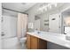 Bright bathroom featuring a large mirror, vanity with wood cabinets, and shower with neutral-tone curtain at 2508 Melville Rd, North Charleston, SC 29406