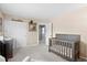 Well-lit Bedroom with neutral walls, a dark wood crib, and plush gray carpeting throughout at 2508 Melville Rd, North Charleston, SC 29406