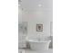 Elegant bathroom with a freestanding soaking tub and stylish fixtures under framed art and mirrors at 3554 Clambank Dr, Mount Pleasant, SC 29466