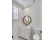 Elegant bathroom features a round mirror above a vanity with white cabinets and a toilet at 3554 Clambank Dr, Mount Pleasant, SC 29466
