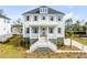Stunning two-story home features white siding, sage shutters, and an inviting front porch with marsh views at 3554 Clambank Dr, Mount Pleasant, SC 29466