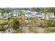 An exterior shot of a white home surrounded by mature trees and landscaping is reflected in a marshy river in the background at 3554 Clambank Dr, Mount Pleasant, SC 29466