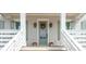 Inviting front porch features a sage door, seasonal decor, and stairs at 3554 Clambank Dr, Mount Pleasant, SC 29466