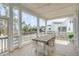 Inviting screened porch with wooden table, seating, and scenic waterfront views at 3554 Clambank Dr, Mount Pleasant, SC 29466