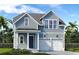 Charming two-story home featuring a two-car garage, light blue siding, and a well-manicured lawn at 365 Trailmore Ln, Summerville, SC 29486
