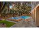 Expansive backyard featuring a luxurious pool and spa combination surrounded by lush greenery and ample patio space at 4008 Cameron Blvd, Isle of Palms, SC 29451