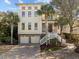 Stunning three-story home with a beautiful brick driveway, two-car garage, and lush tropical landscaping at 4008 Cameron Blvd, Isle of Palms, SC 29451
