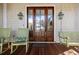 Charming front porch featuring a wooden bench swing, rocking chairs, and a decorative wooden and glass front door at 4008 Cameron Blvd, Isle of Palms, SC 29451
