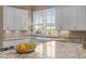 Bright kitchen featuring white cabinets, granite countertops, and large windows at 4008 Cameron Blvd, Isle of Palms, SC 29451