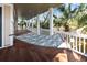 Enjoy this covered porch featuring a tropical hammock and gorgeous wood flooring at 4008 Cameron Blvd, Isle of Palms, SC 29451