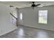 Bright living room with gray wood flooring, ceiling fan, and a white front door and staircase at 415 Aberdeen Cir, Summerville, SC 29483
