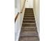 Carpeted staircase with wooden handrail and white trim leads to the upper level of the home at 415 Aberdeen Cir, Summerville, SC 29483