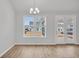 Bright dining area featuring hardwood floors, modern chandelier, and a large window with backyard views at 419 Grove End Rd, Moncks Corner, SC 29461