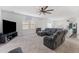 Open-concept living room with a large sofa, TV, and a ceiling fan, illuminated by natural light at 458 Pender Woods Dr, Summerville, SC 29486