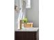 Bathroom with a sink with gold faucet, and wicker container with greenery as decor at 511 Sarah St, Charleston, SC 29407