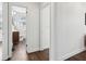 Hallway view with access to the bathroom. The floors are wood and the walls are painted white at 511 Sarah St, Charleston, SC 29407