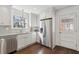Updated kitchen with stainless steel appliances, sleek white cabinets, hardwood floors and a view to the door at 511 Sarah St, Charleston, SC 29407