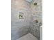 Newly tiled shower with gray tile, a built-in shelf, and bronze hardware at 511 Sarah St, Charleston, SC 29407