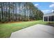 The backyard has a cement patio surrounded by tall trees and green grass at 523 Eastern Isle Ave, Summerville, SC 29486